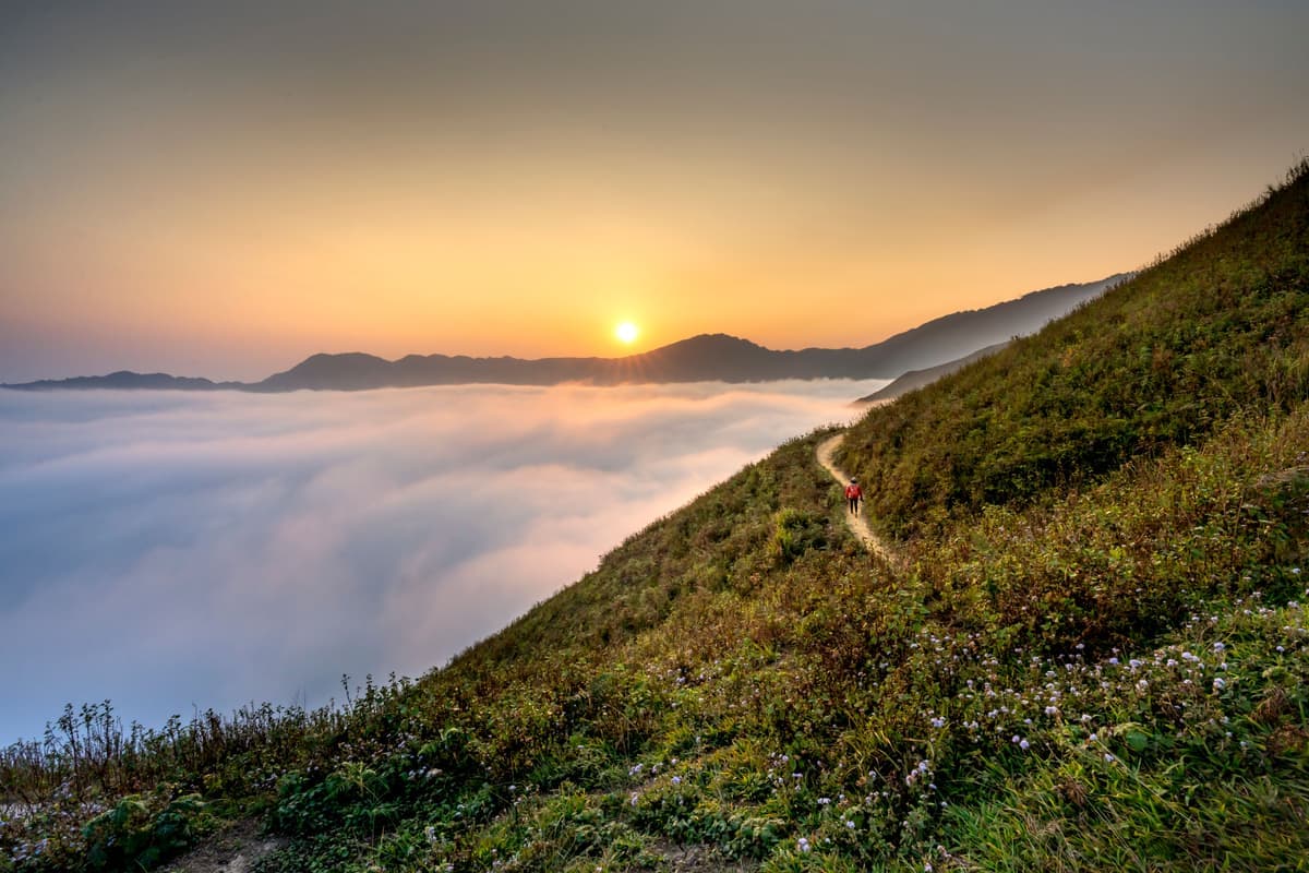 A hiker on a mountain trail at dusk