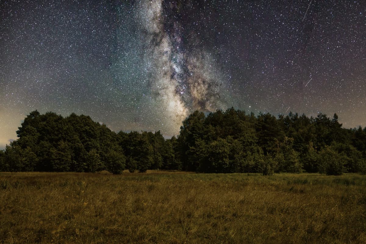 A night sky over a dark landscape
